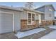 Home's exterior features gray siding, brick details, and a two-car garage at 16046 E Harvard Ave, Aurora, CO 80013