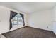 Bright living room with large window, neutral walls, and dark gray carpeting at 16046 E Harvard Ave, Aurora, CO 80013