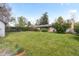 Spacious backyard with a lush lawn, mature trees, and a shed for extra storage at 8305 Eaton Way, Arvada, CO 80003
