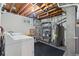 Unfinished basement with exposed ceiling, shelving and washer and dryer at 8305 Eaton Way, Arvada, CO 80003