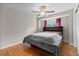Cozy bedroom with hardwood flooring, a ceiling fan, and a built-in headboard at 8305 Eaton Way, Arvada, CO 80003