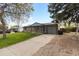 Charming single-story home featuring a well-manicured lawn and a long, paved driveway leading to the garage at 8305 Eaton Way, Arvada, CO 80003