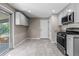 Spacious kitchen with stainless steel appliances, light gray cabinets, and a door leading to the backyard at 8305 Eaton Way, Arvada, CO 80003