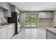 Bright kitchen with modern appliances, light gray cabinets, granite countertops, and a sliding glass door to the backyard at 8305 Eaton Way, Arvada, CO 80003