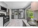 Well-lit kitchen featuring stainless steel appliances, light gray cabinets, and a dining area with contemporary chairs at 8305 Eaton Way, Arvada, CO 80003