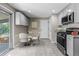 Cozy kitchen space featuring gray cabinets, stainless steel appliances, and a small dining table and chairs at 8305 Eaton Way, Arvada, CO 80003