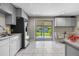 Bright kitchen with modern appliances, light gray cabinets, granite countertops, and a sliding glass door to the backyard at 8305 Eaton Way, Arvada, CO 80003
