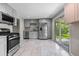 Well-lit kitchen featuring stainless steel appliances, light gray cabinets, and a sliding glass door to the backyard at 8305 Eaton Way, Arvada, CO 80003