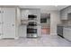 Modern kitchen with stainless steel appliances, light gray cabinets, granite countertops, and tile flooring at 8305 Eaton Way, Arvada, CO 80003