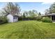 Well-maintained backyard featuring a large, grassy area, a shed, and established greenery at 8305 Eaton Way, Arvada, CO 80003