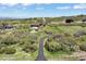 An aerial view showcases a winding driveway leading to a home in a rural, grassy setting at 1701 Creedmoor Ct, Castle Rock, CO 80109