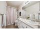 The bathroom features dual sinks, a shower with a curtain, white cabinets, and tile floors at 24783 E Arkansas Pl, Aurora, CO 80018