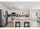 Well-lit kitchen with white cabinets, stainless steel appliances, and a breakfast bar area at 24783 E Arkansas Pl, Aurora, CO 80018