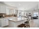Bright, modern kitchen with an island, white cabinetry, and views into the living spaces at 24783 E Arkansas Pl, Aurora, CO 80018