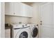 The laundry room features a front loading washing machine and dryer and storage cabinets at 24783 E Arkansas Pl, Aurora, CO 80018