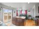 Bright kitchen with island, wooden floor, and sliding door to the outside patio at 892 Macaw St, Brighton, CO 80601