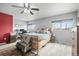 Spacious main bedroom with a ceiling fan, large windows, and a comfortable seating area at 892 Macaw St, Brighton, CO 80601