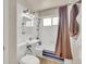 Compact bathroom featuring white tile walls, pedestal sink, and a shower-tub combination with a curtain at 1225 S Honey Way, Denver, CO 80224