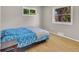 Cozy bedroom featuring hardwood floors, windows providing natural light, and a comfortable bed with a blue patterned comforter at 1225 S Honey Way, Denver, CO 80224