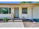 Charming home front entrance featuring a light yellow exterior and tidy landscaping at 1225 S Honey Way, Denver, CO 80224