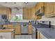 Kitchen has stainless steel appliances, wood cabinets, and plenty of natural light from a large window at 1225 S Honey Way, Denver, CO 80224