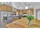 Updated kitchen with stainless steel refrigerator and a butcher block breakfast bar with seating at 1225 S Honey Way, Denver, CO 80224