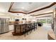 Basement wet bar with stone countertop and seating at 9005 Stonecrest Way, Highlands Ranch, CO 80129