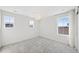 Bright bedroom with three windows, plush carpet, and a modern light fixture at 9175 Uravan Ct, Commerce City, CO 80022