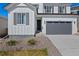Inviting home exterior features a dark front door, and a gray garage door at 9175 Uravan Ct, Commerce City, CO 80022
