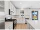 Bright kitchen featuring stainless steel appliances, white cabinets, and ample counter space at 9175 Uravan Ct, Commerce City, CO 80022