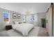 Staged primary bedroom features large window, plush carpet and a barn door to the ensuite bathroom at 9175 Uravan Ct, Commerce City, CO 80022