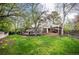 Expansive backyard with lush green lawn, a wooden deck, patio and a covered pergola for outdoor living at 4011 S Ivy Ln, Cherry Hills Village, CO 80111