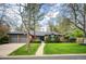Charming brick home with mature trees, manicured lawn, and an attached two-car garage at 4011 S Ivy Ln, Cherry Hills Village, CO 80111