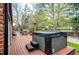Backyard deck featuring a hot tub, with mature trees creating a private and serene outdoor space at 4011 S Ivy Ln, Cherry Hills Village, CO 80111