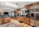 Well-lit kitchen featuring stainless steel appliances, wood cabinets and an adjacent dining area at 4011 S Ivy Ln, Cherry Hills Village, CO 80111