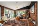 Cozy sunroom with brick walls, stylish furniture, and large windows overlooking the lush outdoors at 4011 S Ivy Ln, Cherry Hills Village, CO 80111