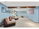 This carpeted basement is illuminated by recessed lights and natural light at 6222 S Ames Ct, Littleton, CO 80123