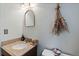 Stylish half bathroom with a granite countertop, decorative mirror, and modern fixtures at 6222 S Ames Ct, Littleton, CO 80123
