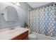 Traditional bathroom featuring a sink vanity with a warm cherry wood finish, and a shower-tub combo at 6222 S Ames Ct, Littleton, CO 80123