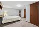 This carpeted bedroom features a lamp, and two wooden doors at 6222 S Ames Ct, Littleton, CO 80123