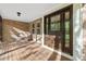 Inviting front porch with a brick facade, wooden deck, and a beautiful decorative glass front door at 6222 S Ames Ct, Littleton, CO 80123