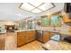 Bright kitchen with granite countertops, stainless steel appliances, and a view of the living room at 6222 S Ames Ct, Littleton, CO 80123