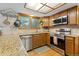 Well-equipped kitchen featuring granite counters, stainless steel appliances, and wood cabinetry at 6222 S Ames Ct, Littleton, CO 80123