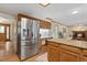Bright kitchen with stainless steel refrigerator, wooden cabinets, and granite countertops at 6222 S Ames Ct, Littleton, CO 80123