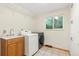 Bright laundry room with sink, washer and dryer, and practical storage shelves at 6222 S Ames Ct, Littleton, CO 80123