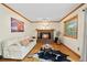 Comfortable living room featuring a brick fireplace, hardwood floors, and ample natural light at 6222 S Ames Ct, Littleton, CO 80123