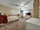 Spacious bedroom featuring neutral walls, large bed, desk, shelves, dresser, and ceiling fan with a light at 10878 Grange Creek Dr, Thornton, CO 80233