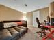 A bedroom with an office setup featuring a couch, gaming chair, and a comfortable bed space at 10878 Grange Creek Dr, Thornton, CO 80233
