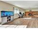 Spacious living room boasts hardwood floors, a brick fireplace, and ample natural light from a large window at 10878 Grange Creek Dr, Thornton, CO 80233