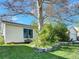 Lush side yard featuring a mature tree, a small stone garden, and a cozy bench for relaxing at 10878 Grange Creek Dr, Thornton, CO 80233